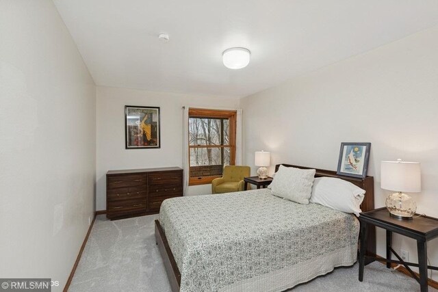 bedroom featuring light carpet and baseboards