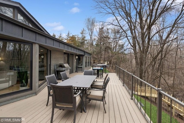 wooden deck featuring grilling area and outdoor dining area