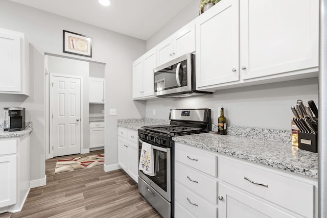 7371 Kalland Cir NE, Otsego, MN 55301 - kitchen with stainless steel appliances, white cabinetry, light wood-style flooring, recessed lighting, and light stone countertops