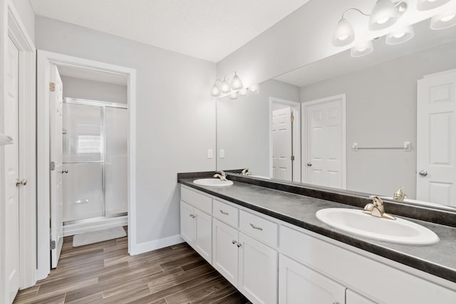 7371 Kalland Cir NE, Otsego, MN 55301 - full bath with double vanity, a stall shower, wood finished floors, and baseboards