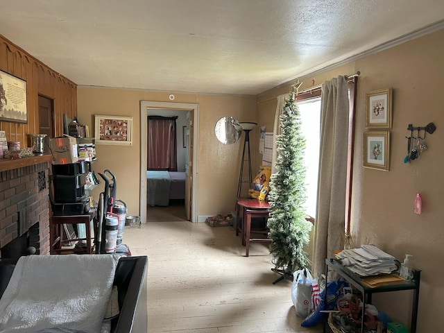 living room with a brick fireplace and light wood-style flooring