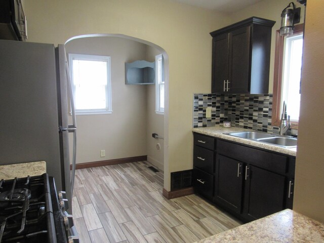 718 Winifred St, Worthington, MN 56187 - kitchen with gas range, a sink, light countertops, and freestanding refrigerator