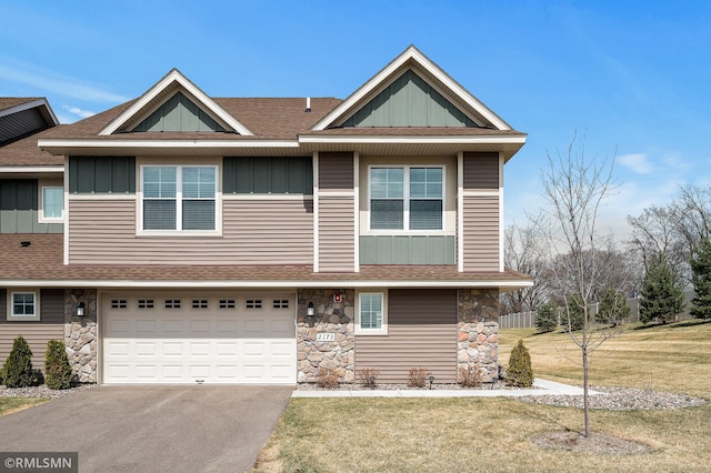 2173 Heron Ct, Lino Lakes, MN 55038 - view of front facade with board and batten siding, a shingled roof, driveway, and stone siding