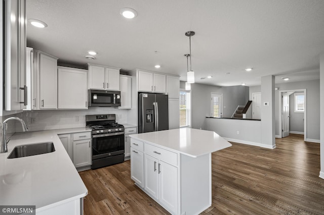 2173 Heron Ct, Lino Lakes, MN 55038 - kitchen with a sink, a center island, baseboards, tasteful backsplash, and appliances with stainless steel finishes