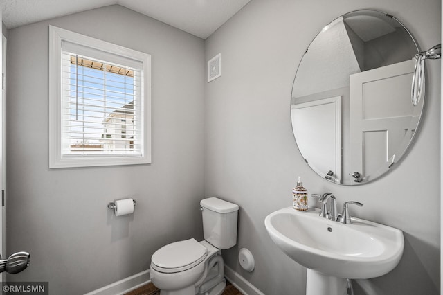 2173 Heron Ct, Lino Lakes, MN 55038 - half bathroom featuring vaulted ceiling, a sink, baseboards, toilet, and visible vents