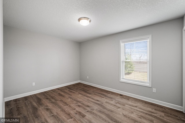 2173 Heron Ct, Lino Lakes, MN 55038 - empty room featuring visible vents, baseboards, a textured ceiling, and dark wood-style flooring