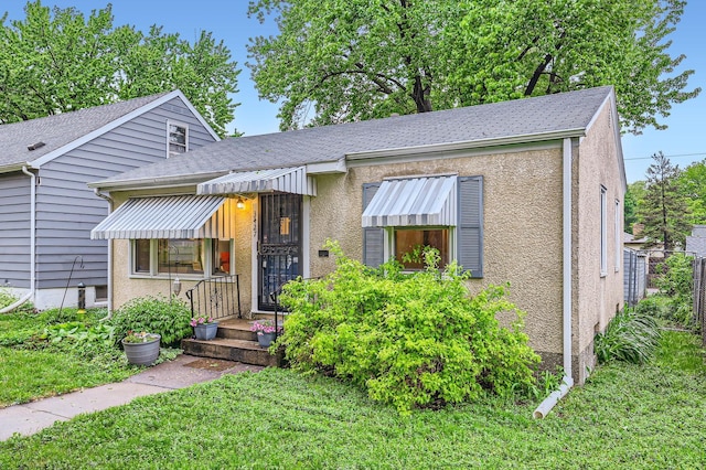3427 Upton Ave N, Minneapolis, MN 55412 - view of front of property with a front lawn, roof with shingles, and stucco siding