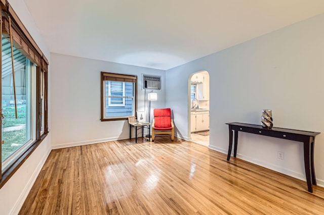 3427 Upton Ave N, Minneapolis, MN 55412 - sitting room with light wood-style floors, arched walkways, baseboards, and a wall mounted air conditioner