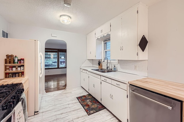 3427 Upton Ave N, Minneapolis, MN 55412 - kitchen featuring a sink, stainless steel dishwasher, arched walkways, healthy amount of natural light, and a textured ceiling
