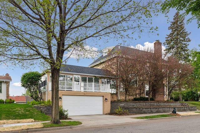 view of front of home with driveway, a garage, a front lawn, and a chimney