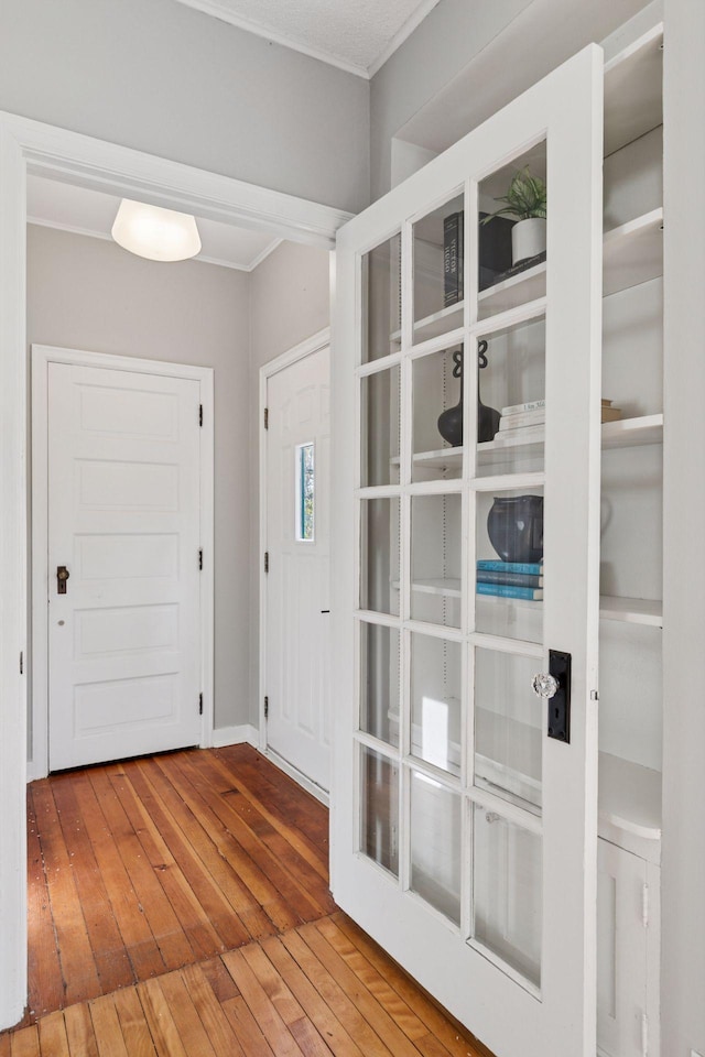 foyer entrance featuring hardwood / wood-style flooring and crown molding