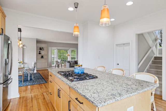 kitchen with stainless steel appliances, light wood finished floors, a breakfast bar area, ornamental molding, and recessed lighting
