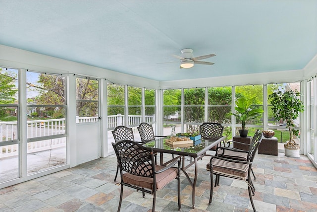 sunroom with a ceiling fan and outdoor dining space