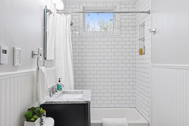 full bath featuring wainscoting, shower / tub combo with curtain, and vanity