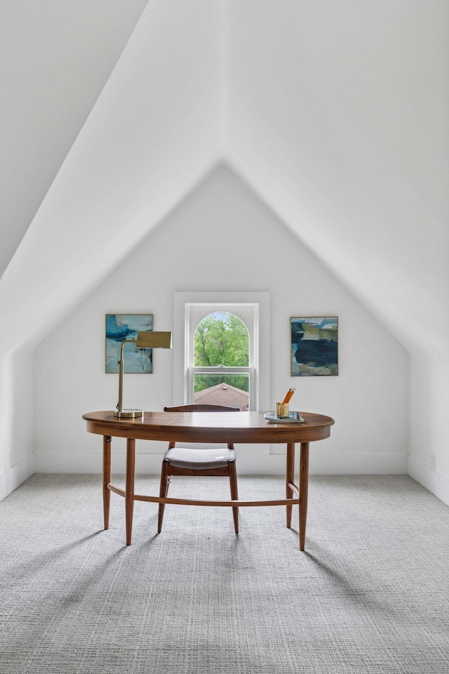 carpeted office space featuring lofted ceiling