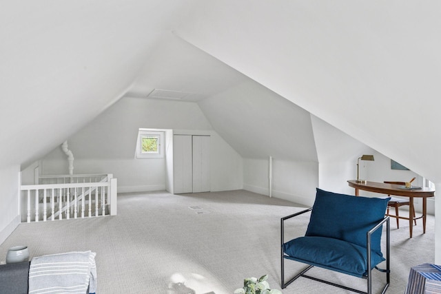 living area with carpet floors, lofted ceiling, baseboards, and an upstairs landing