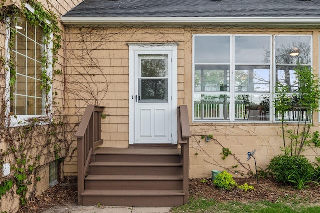 property entrance featuring roof with shingles