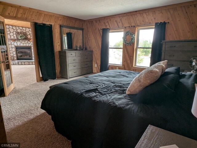 32255 County 21, Browerville, MN 56438 - bedroom featuring carpet, wood walls, a textured ceiling, and a stone fireplace