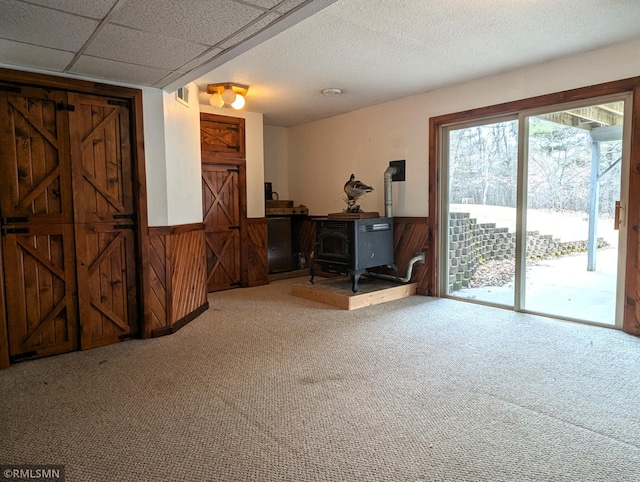 32255 County 21, Browerville, MN 56438 - carpeted living room with a wood stove, a wainscoted wall, and wood walls