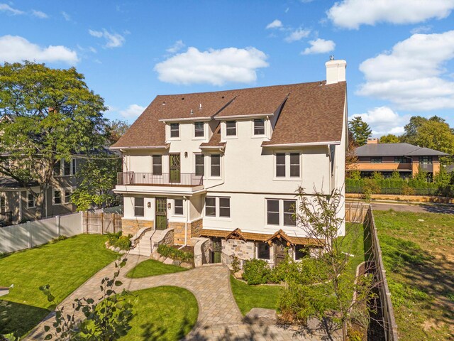 1647 26th St, Minneapolis, MN 55405 - back of property featuring a balcony, stone siding, stucco siding, and a chimney
