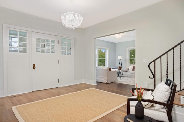 1647 26th St, Minneapolis, MN 55405 - foyer featuring stairway, wood finished floors, a chandelier, and baseboards
