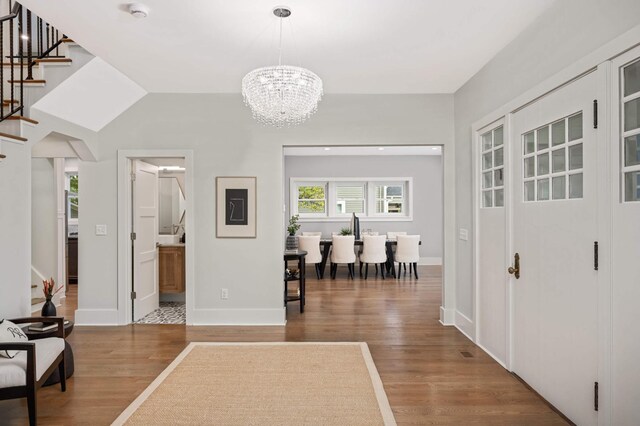 1647 26th St, Minneapolis, MN 55405 - entrance foyer featuring stairway, a chandelier, wood finished floors, and baseboards
