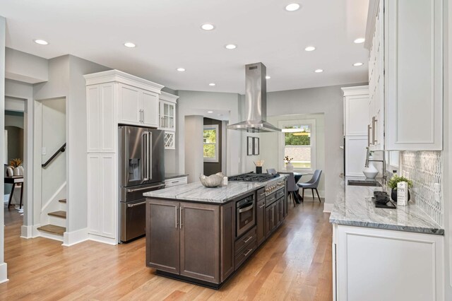 1647 26th St, Minneapolis, MN 55405 - kitchen featuring stainless steel appliances, island exhaust hood, white cabinetry, a center island, and recessed lighting