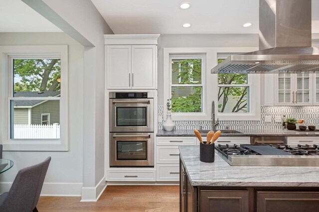 1647 26th St, Minneapolis, MN 55405 - kitchen featuring island exhaust hood, stainless steel appliances, a sink, healthy amount of natural light, and recessed lighting