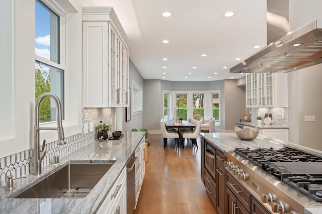 1647 26th St, Minneapolis, MN 55405 - kitchen with a sink, range hood, stainless steel appliances, recessed lighting, and light wood finished floors