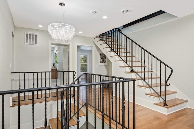 1647 26th St, Minneapolis, MN 55405 - staircase featuring wood finished floors, recessed lighting, a chandelier, and baseboards