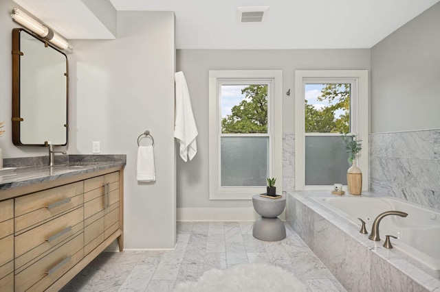 1647 26th St, Minneapolis, MN 55405 - bathroom with a tub to relax in, marble look tile flooring, vanity, and baseboards