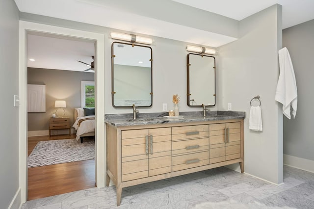 1647 26th St, Minneapolis, MN 55405 - ensuite bathroom with baseboards, double vanity, ceiling fan, and marble look tiles