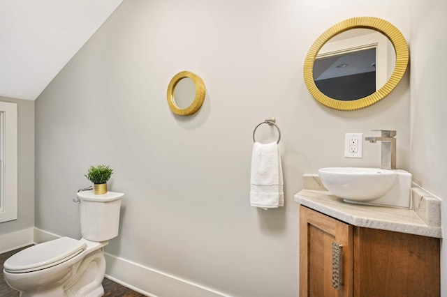 1647 26th St, Minneapolis, MN 55405 - half bath featuring baseboards, toilet, vanity, and wood finished floors