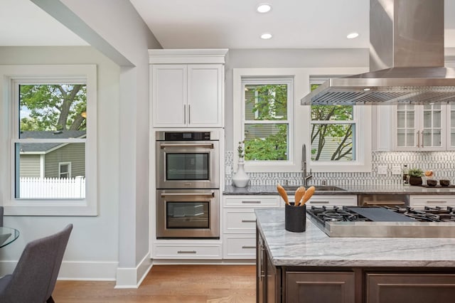 1647 26th St, Minneapolis, MN 55405 - kitchen with stainless steel appliances, island exhaust hood, healthy amount of natural light, a sink, and recessed lighting