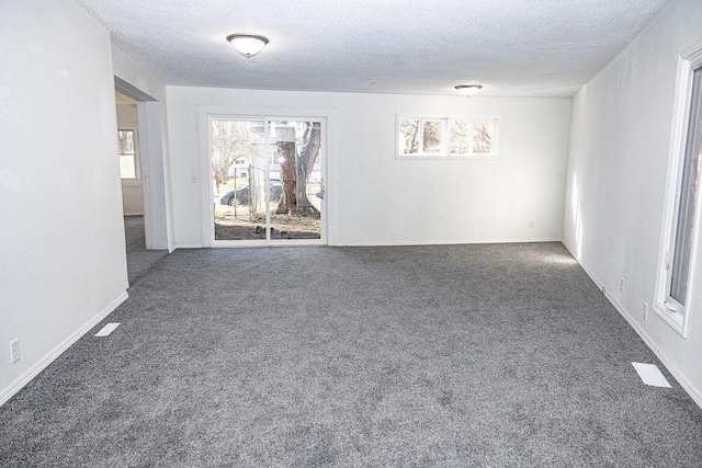 spare room featuring baseboards, carpet flooring, and a textured ceiling