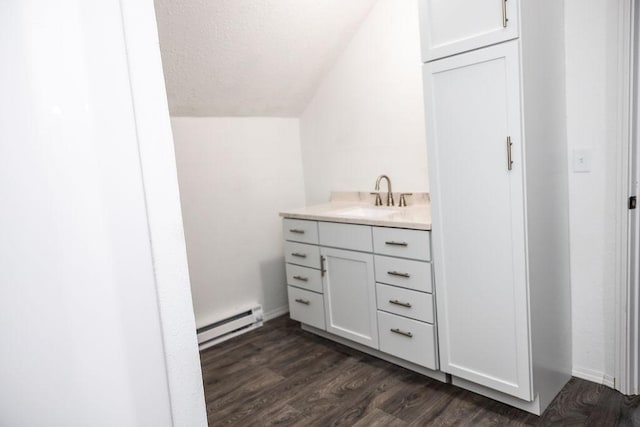 bathroom featuring a textured ceiling, baseboards, baseboard heating, wood finished floors, and vanity