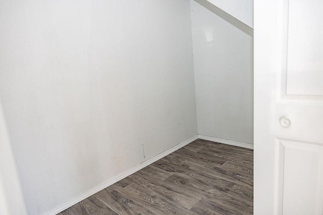 unfurnished room featuring dark wood-type flooring and baseboards