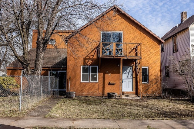 view of front facade featuring entry steps, a balcony, and fence