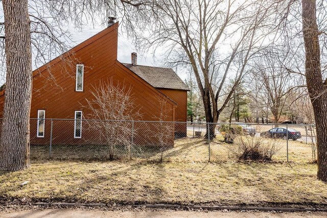 view of home's exterior featuring a chimney and fence