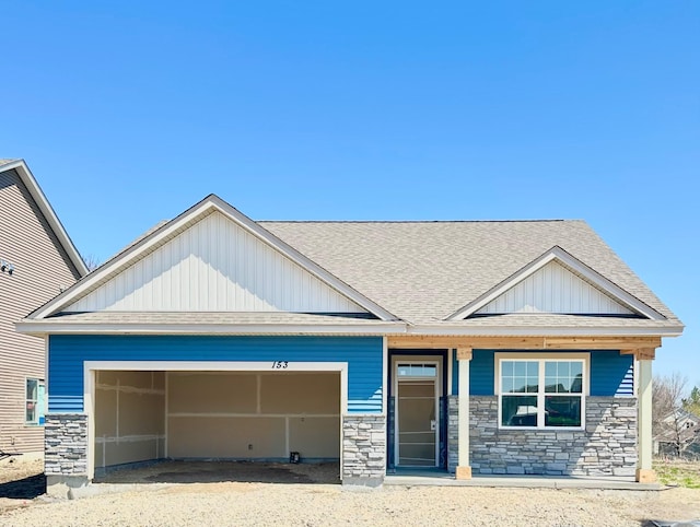craftsman-style home with a garage, board and batten siding, stone siding, and a shingled roof
