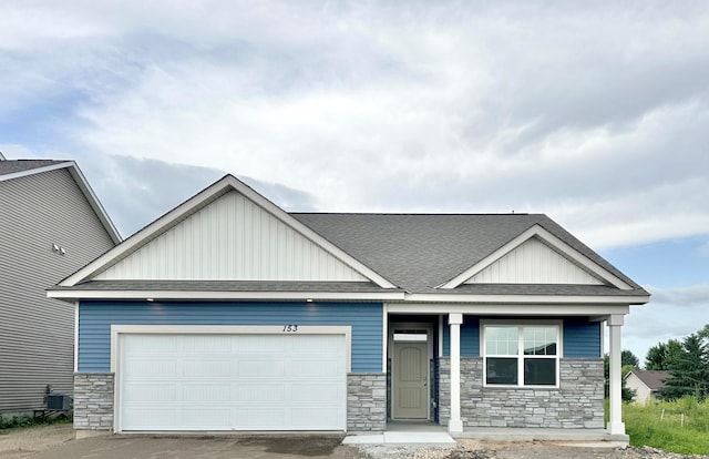153 Snowdrop Trl, Waconia, MN 55387 - craftsman house featuring stone siding, board and batten siding, a garage, a shingled roof, and driveway