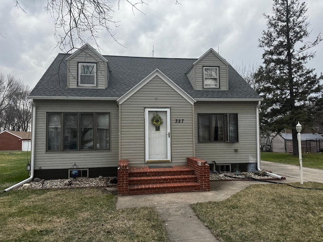new england style home with roof with shingles and a front yard