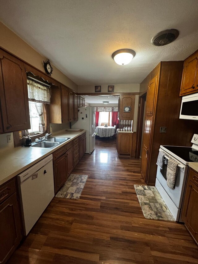 327 2nd St SW, Clara City, MN 56222 - kitchen with white appliances, a sink, dark wood finished floors, light countertops, and a textured ceiling