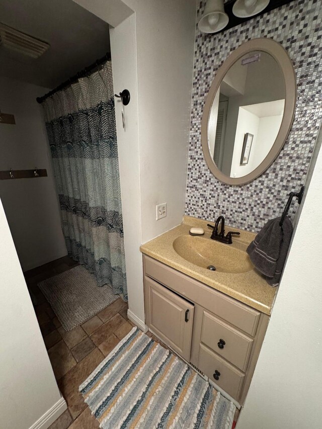 327 2nd St SW, Clara City, MN 56222 - full bathroom with vanity, baseboards, decorative backsplash, and stone finish flooring