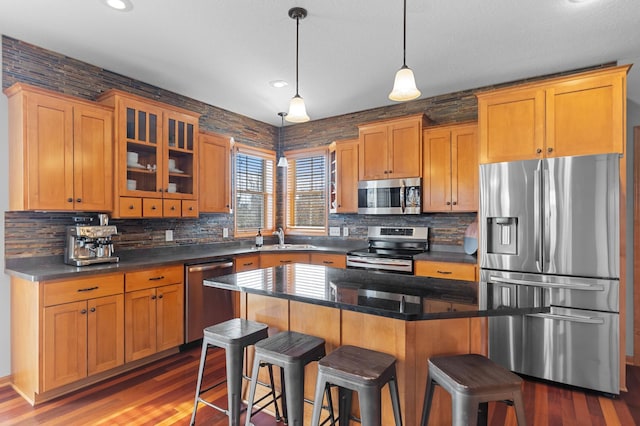 17639 Heidelberg Way, Lakeville, MN 55044 - kitchen with stainless steel appliances, a kitchen breakfast bar, tasteful backsplash, wood finished floors, and glass insert cabinets