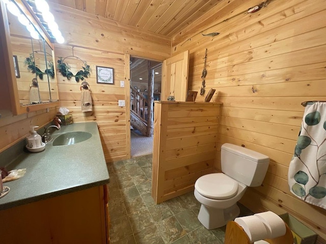17999 Ivy Dr, Park Rapids, MN 56470 - bathroom with wooden walls, wooden ceiling, vanity, toilet, and stone finish floors