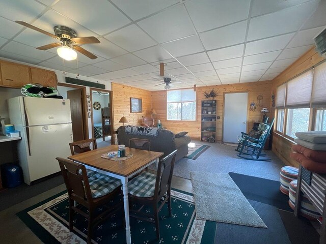 17999 Ivy Dr, Park Rapids, MN 56470 - dining space with a ceiling fan, wood walls, a drop ceiling, and carpet floors
