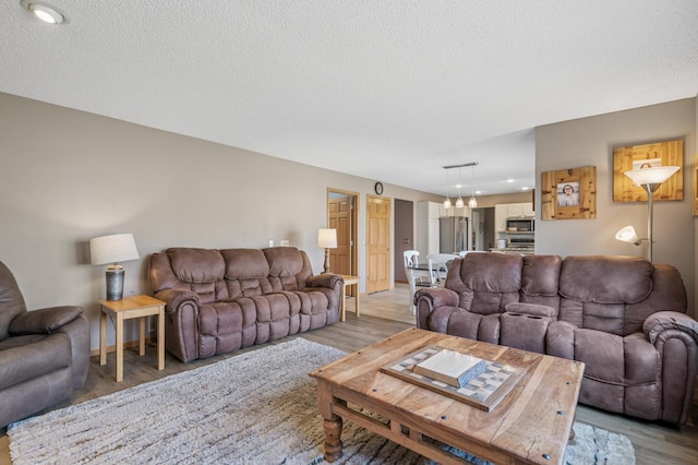 104 Birch Ave NW, Saint Michael, MN 55376 - living room with a chandelier, light wood-style flooring, a textured ceiling, and recessed lighting