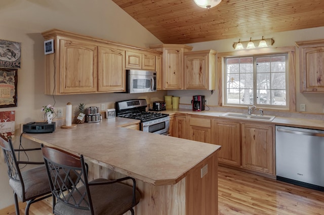 7621 Winter Trl, Breezy Point, MN 56472 - kitchen with stainless steel appliances, light brown cabinetry, a sink, vaulted ceiling, and a breakfast bar area