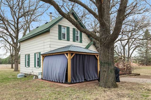 view of property exterior featuring a lawn and a gazebo